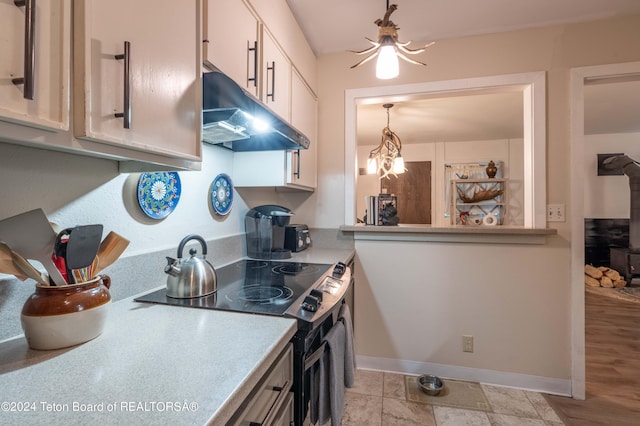 kitchen with electric stove, pendant lighting, and white cabinets