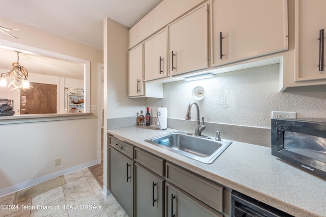 kitchen featuring sink, decorative light fixtures, gray cabinets, and black appliances