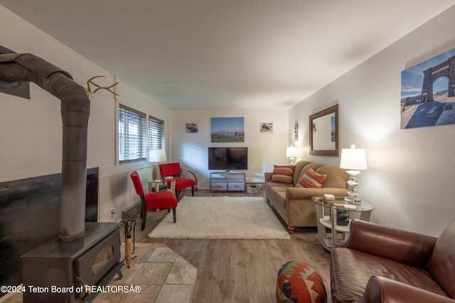 living room featuring light hardwood / wood-style flooring and a wood stove