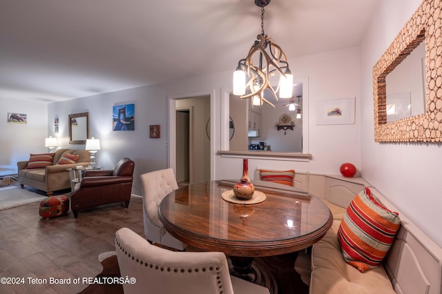 dining space with hardwood / wood-style flooring and a chandelier