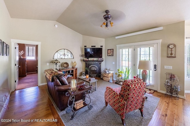 living room featuring ceiling fan, lofted ceiling, and wood-type flooring