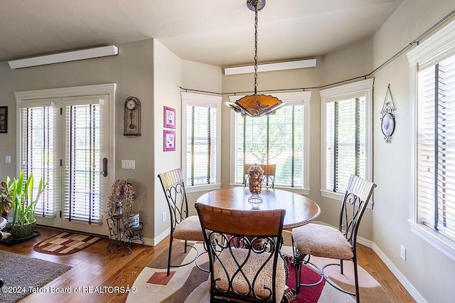 dining space with hardwood / wood-style flooring and french doors