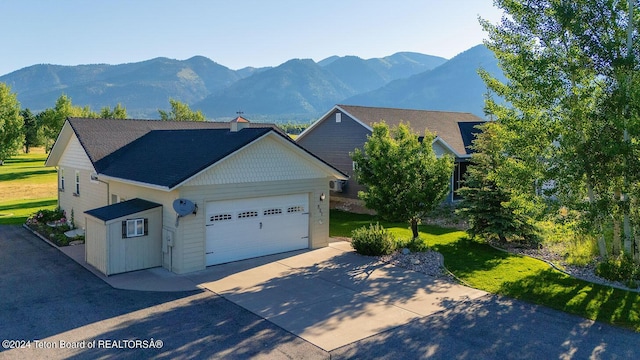 view of front facade with a mountain view, a garage, and a front lawn