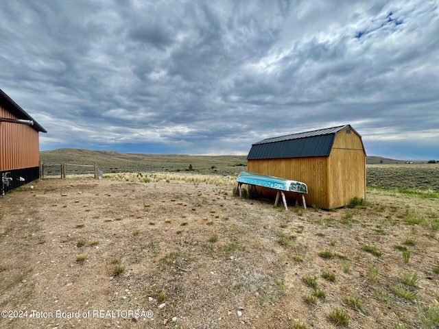 view of yard featuring a rural view and an outbuilding