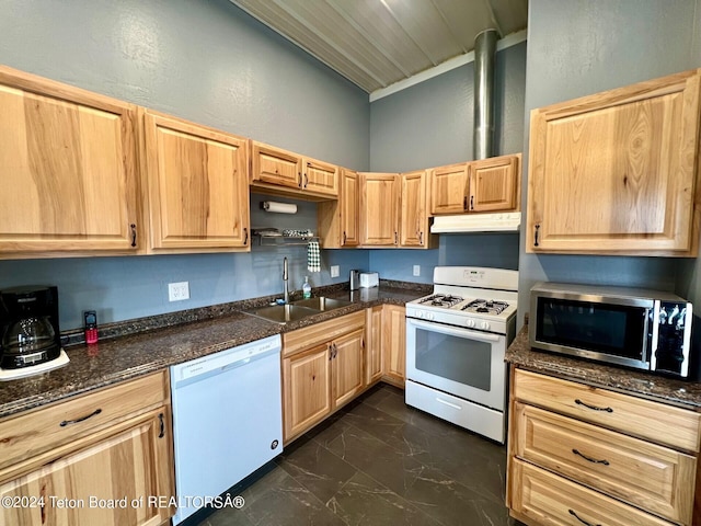 kitchen featuring sink, light brown cabinetry, dark tile patterned flooring, and white appliances