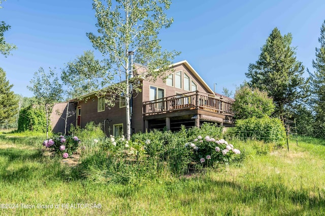 back of house featuring a chimney and a deck