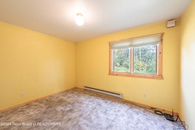 carpeted spare room with a baseboard radiator and baseboards