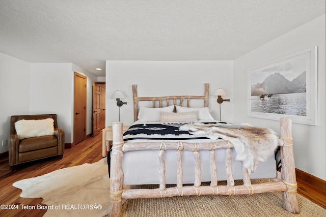 bedroom with hardwood / wood-style flooring and a textured ceiling