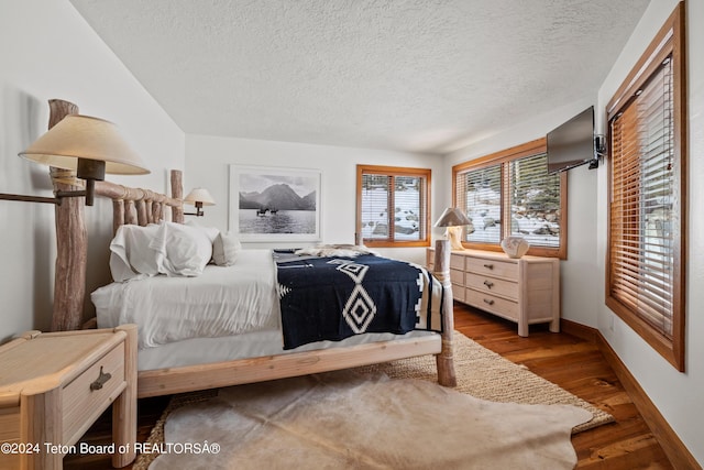 bedroom with wood-type flooring and a textured ceiling