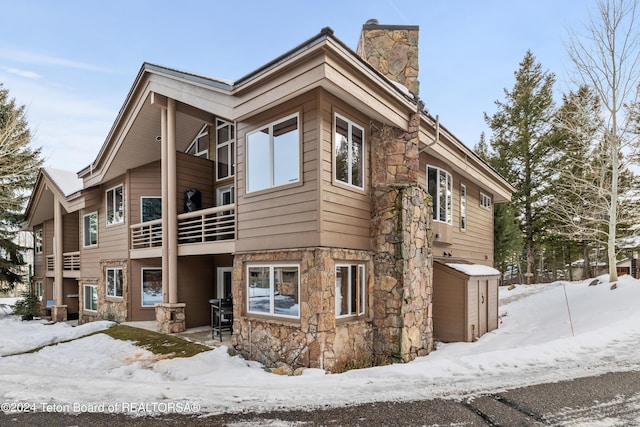 view of snow covered exterior with a balcony