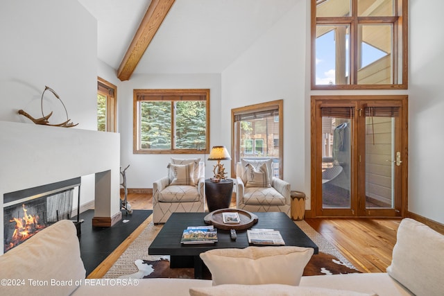 living room featuring vaulted ceiling with beams and hardwood / wood-style floors