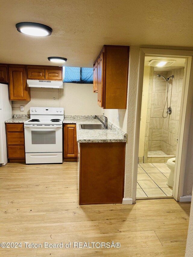 kitchen with light hardwood / wood-style flooring, white appliances, sink, light stone countertops, and a textured ceiling