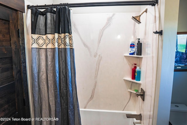 bathroom featuring toilet and shower / bath combo