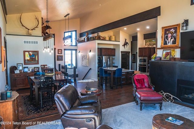 living room with a towering ceiling and hardwood / wood-style flooring