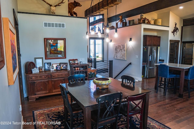 dining room with dark hardwood / wood-style floors and a high ceiling