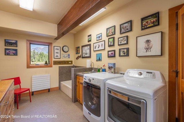 washroom with sink, cabinets, washing machine and clothes dryer, and light carpet