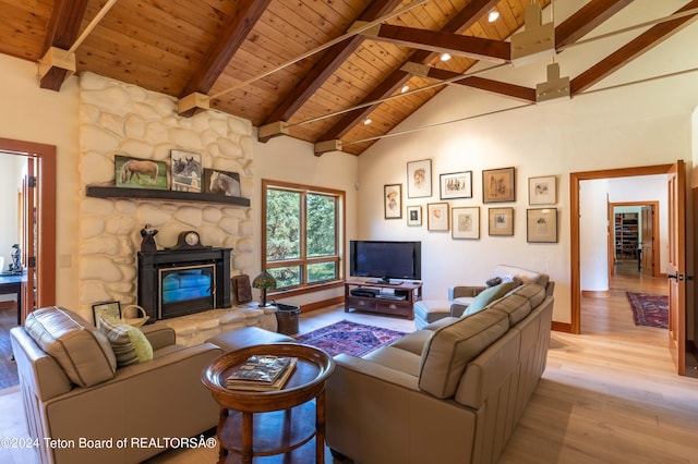 living room featuring light hardwood / wood-style floors, beam ceiling, wooden ceiling, and a fireplace