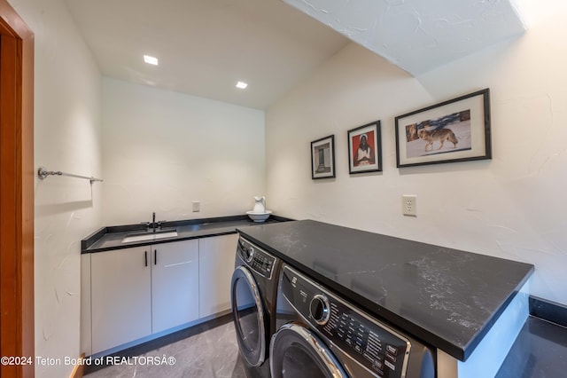 washroom featuring dark tile patterned flooring, cabinets, sink, and independent washer and dryer