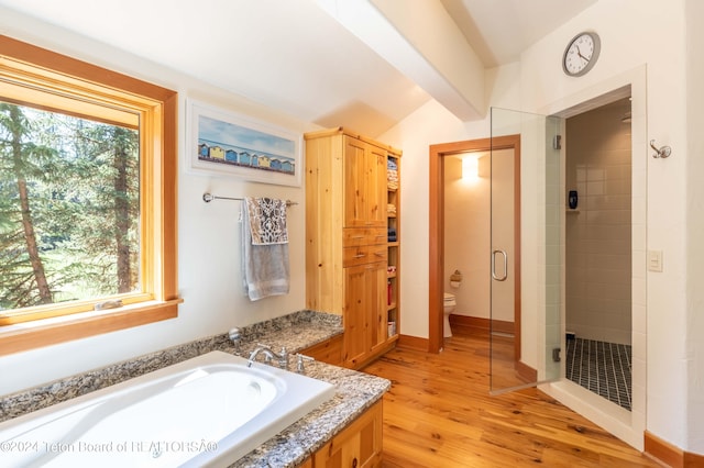 bathroom featuring independent shower and bath, lofted ceiling with beams, hardwood / wood-style floors, and toilet