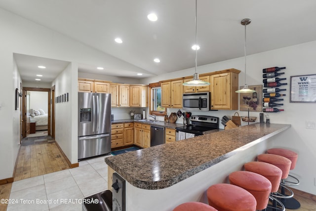 kitchen featuring hanging light fixtures, kitchen peninsula, light wood-type flooring, and stainless steel appliances