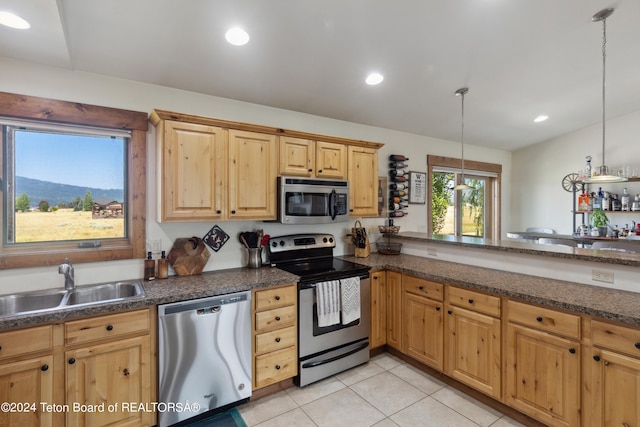 kitchen featuring pendant lighting, sink, appliances with stainless steel finishes, and light tile patterned floors