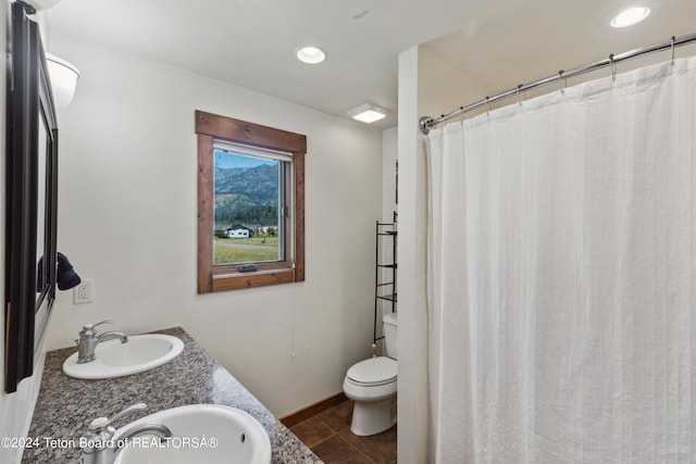 bathroom featuring double vanity, tile patterned flooring, and toilet