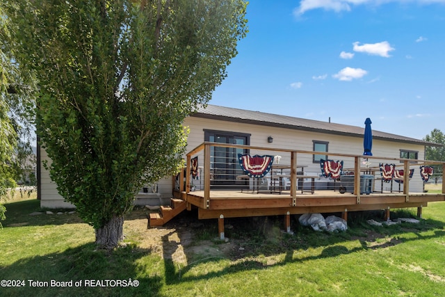 rear view of property with a deck and a yard