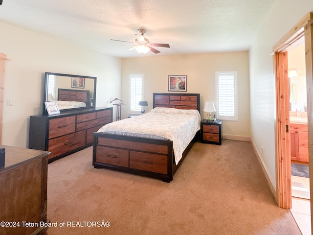 bedroom with multiple windows, ceiling fan, light colored carpet, and a textured ceiling