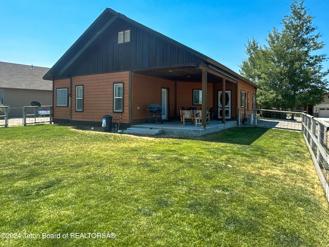 rear view of property with a lawn and a patio