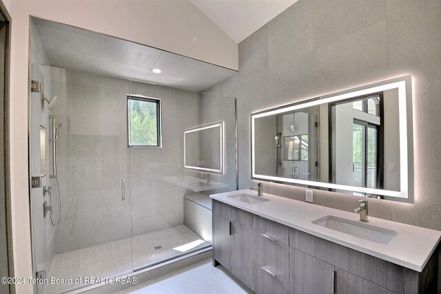 bathroom with vaulted ceiling, walk in shower, and vanity