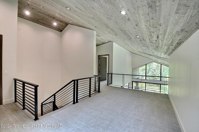 hallway featuring light carpet, wood ceiling, and vaulted ceiling