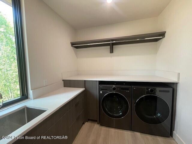 washroom with washer and clothes dryer, sink, and light hardwood / wood-style floors