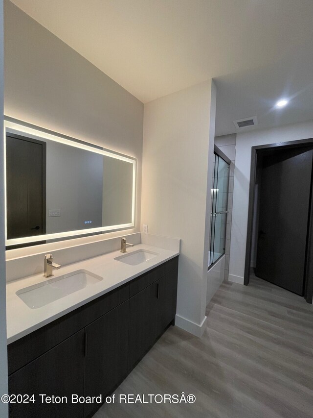 bathroom with vanity, shower / bath combination with glass door, and hardwood / wood-style floors