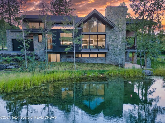 back house at dusk featuring a water view