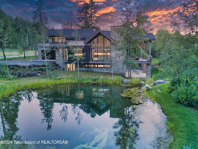 back house at dusk with a water view