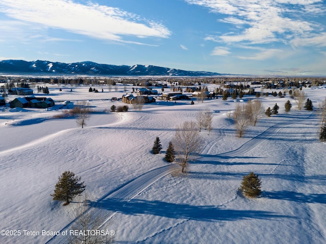 snowy aerial view featuring a mountain view