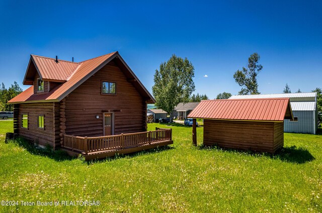 exterior space with a deck, a storage shed, and a lawn