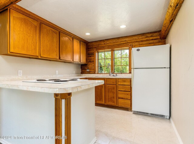 kitchen featuring sink, kitchen peninsula, light tile patterned flooring, and white appliances