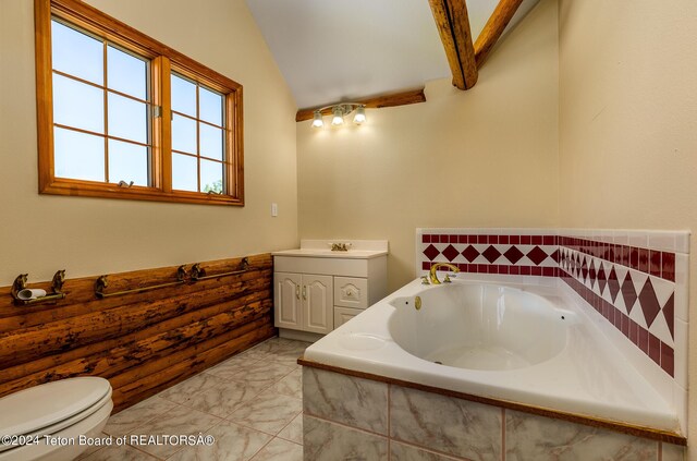 bathroom with tiled bath, vaulted ceiling, tile patterned flooring, vanity, and toilet