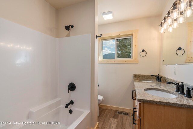 full bathroom with shower / washtub combination, hardwood / wood-style flooring, toilet, and double sink vanity