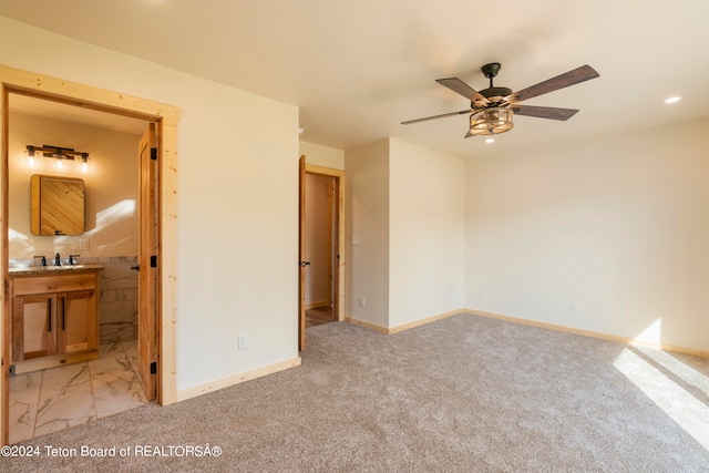 carpeted bedroom with sink, ensuite bath, and ceiling fan