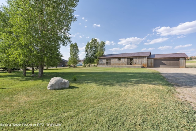 1424 Fairview Dr, Dubois, WY 82513 - view of front of house featuring a garage, gravel driveway, a front yard, and a metal roof