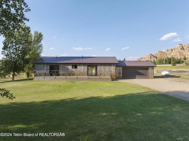 1424 Fairview Dr, Dubois, WY 82513 - view of front of house with dirt driveway, a garage, a metal roof, a front yard, and a mountain view