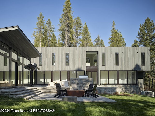 7750 N Lower Granite Ridge Rd, Teton Village, WY 83025 - back of property featuring a patio, a lawn, exterior kitchen, an outdoor fire pit, and central AC unit