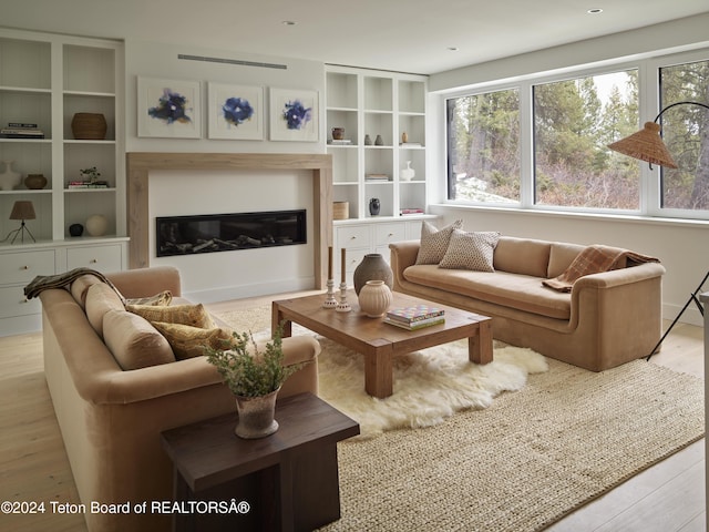 7750 N Lower Granite Ridge Rd, Teton Village, WY 83025 - living room featuring a glass covered fireplace, light wood finished floors, and built in features