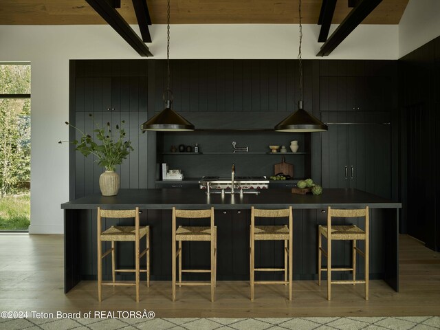 2680 Trader Rd, Jackson, WY 83001 - bar with light wood-style floors, a healthy amount of sunlight, beam ceiling, and a sink