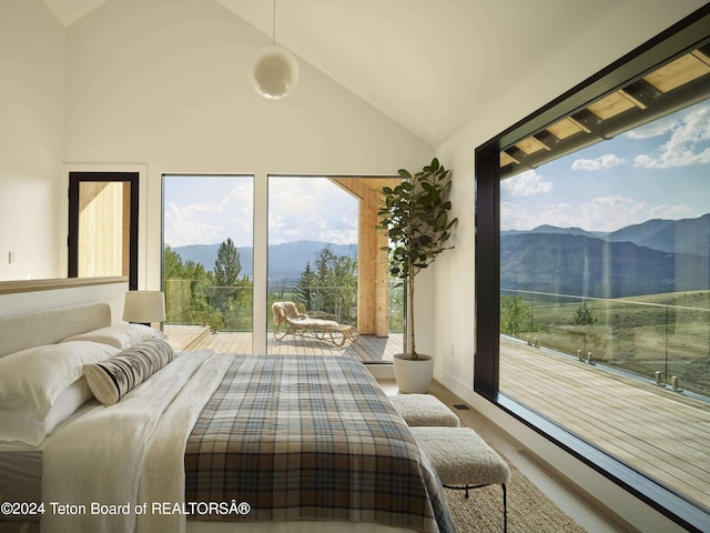 bedroom featuring a mountain view, hardwood / wood-style floors, and high vaulted ceiling