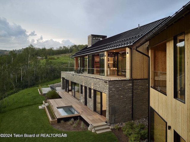 2680 Trader Rd, Jackson, WY 83001 - exterior space featuring stone siding, a yard, metal roof, a chimney, and a standing seam roof