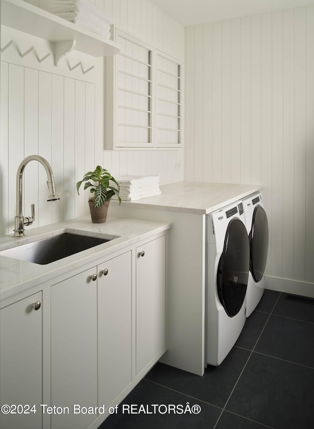 2680 Trader Rd, Jackson, WY 83001 - clothes washing area with washer and clothes dryer, cabinet space, dark tile patterned floors, and a sink