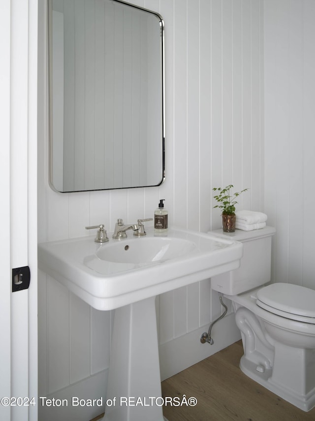 bathroom with toilet and hardwood / wood-style floors